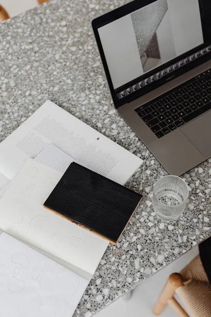 Une maquette de site web affichée sur l’écran d’un MacBook posé sur un bureau de bureau.